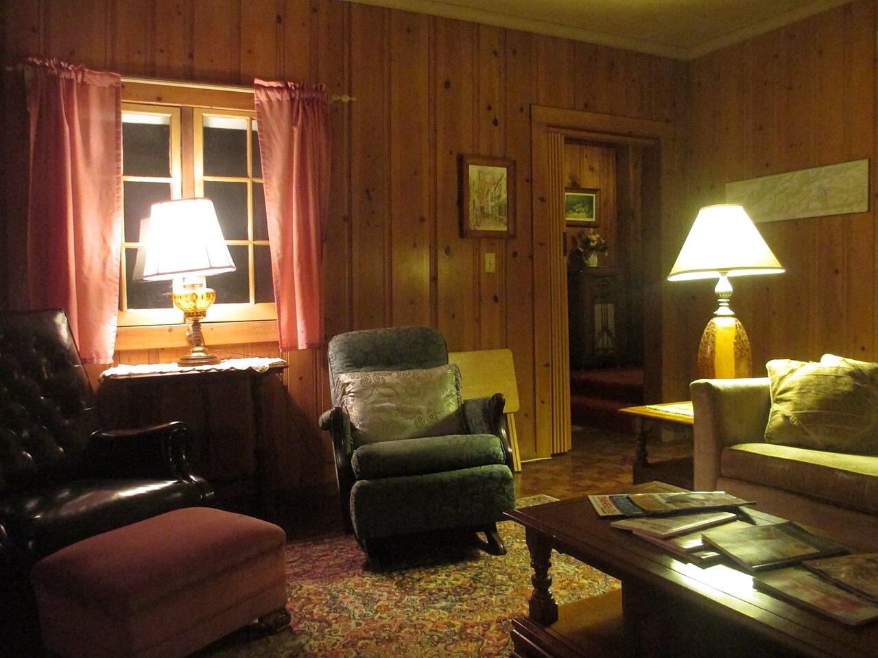 A cozy sitting room with lamps and armchairs