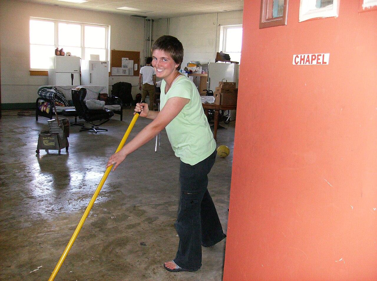 A woman mopping a large floor