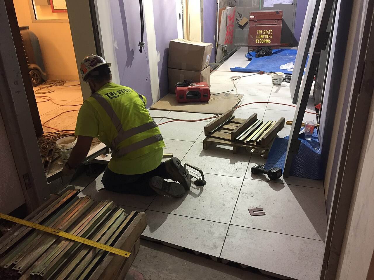 A worker laying floor tile