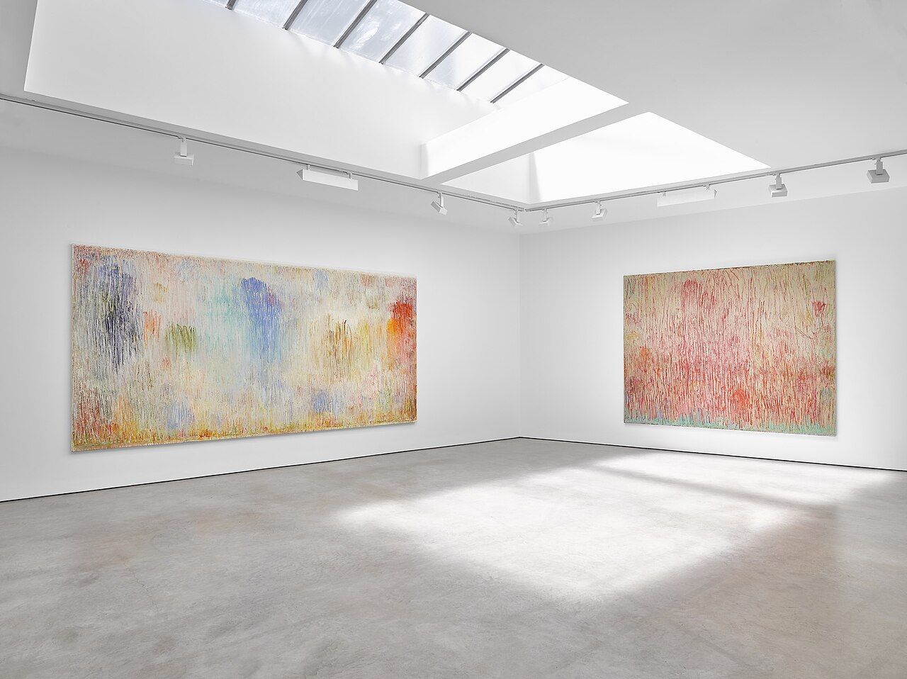 Large paintings hung in a bright white gallery
