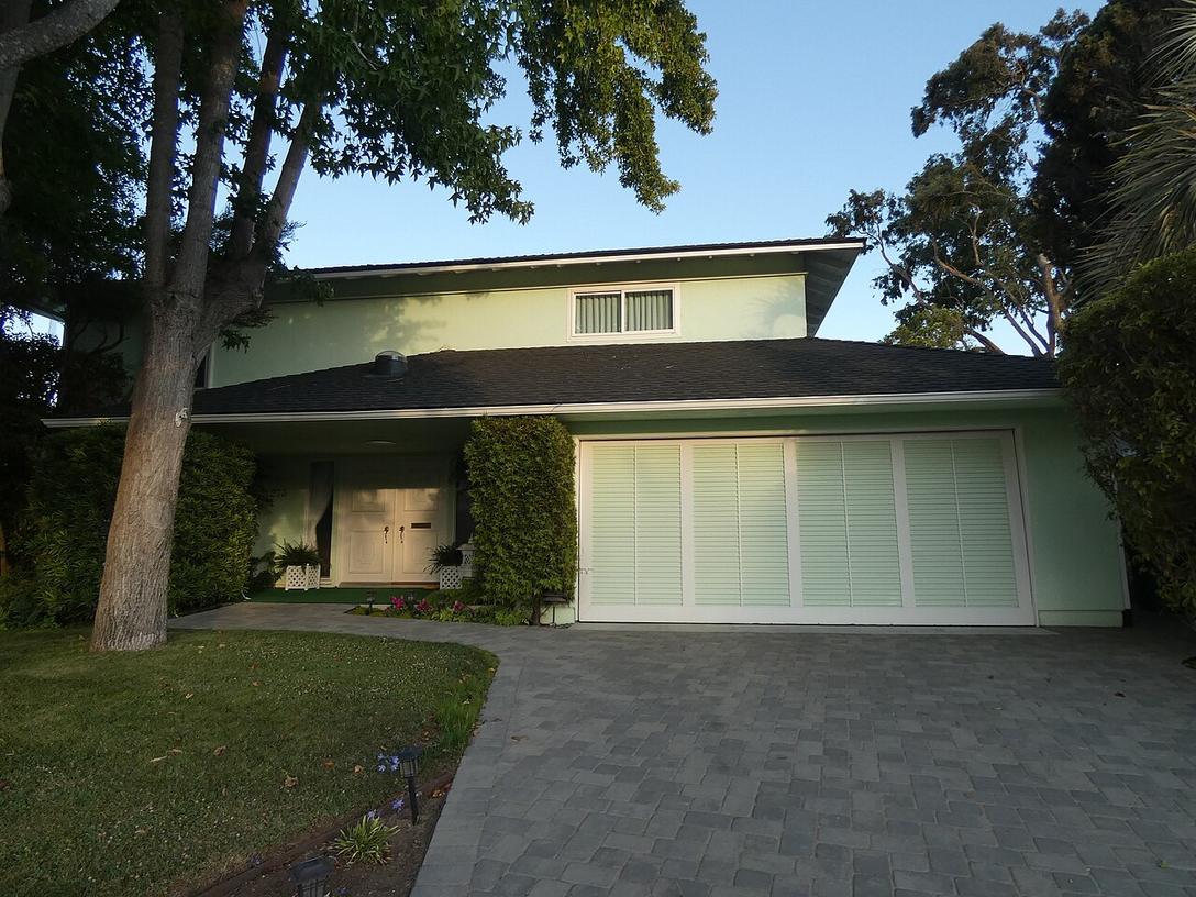 A house with a wide white garage door and driveway
