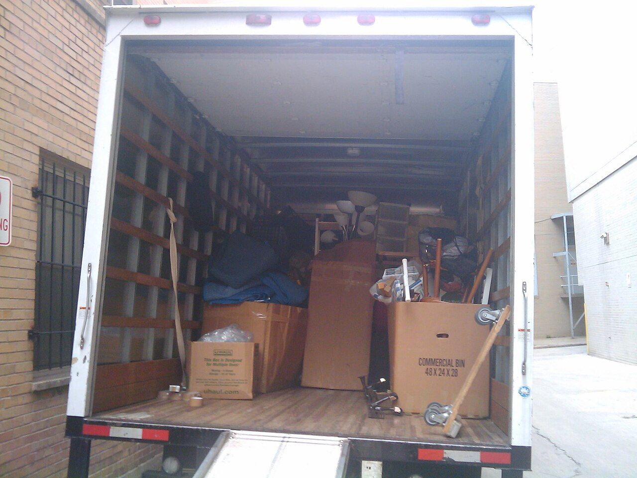 The back of a moving truck loaded with boxes and furniture
