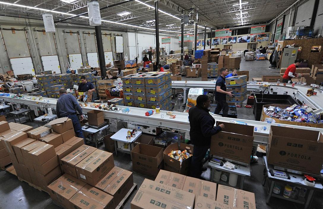 Volunteers sorting boxes in a food bank warehouse