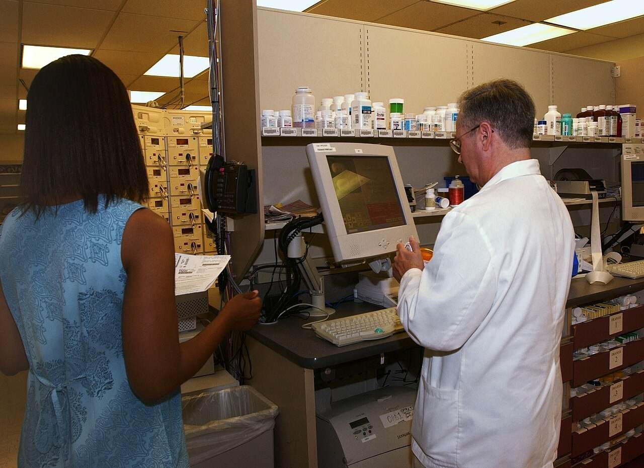 A pharmacist checking a prescription at the counter