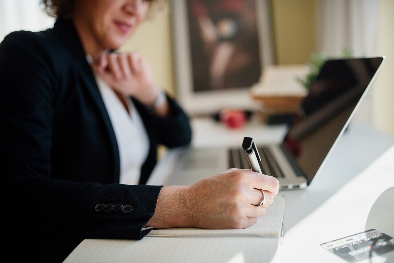 A person taking notes at an office desk