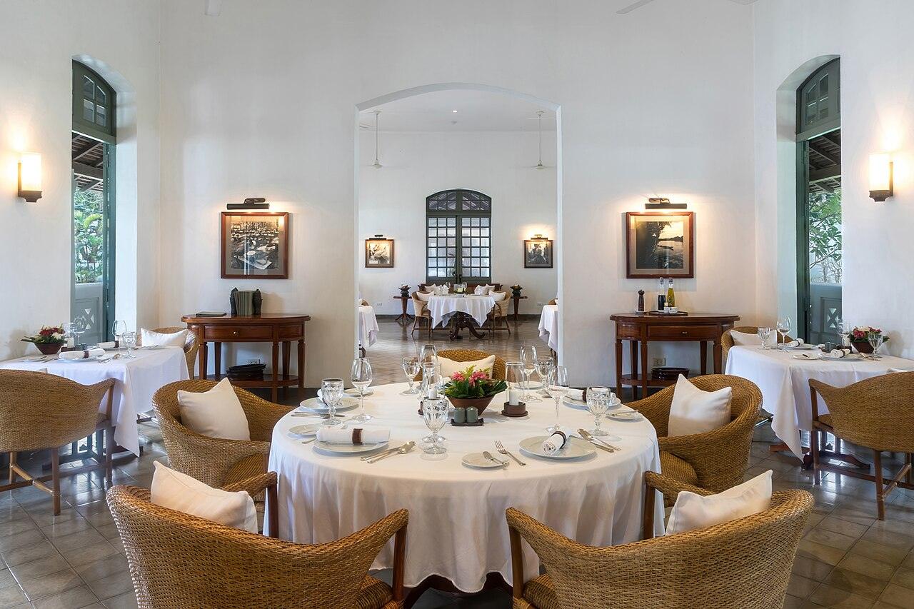 A restaurant dining room with set round tables