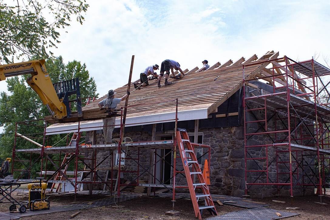 Roofers working on a new roof above scaffolding